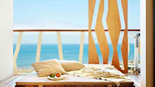 Solstol på en balkong med utsikt mot havet. (AI-generert tekst)