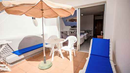 Terrasse med bord, stoler og solseng. (AI-generert tekst)