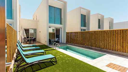 Private villaer med basseng og solsenger. (AI-generert tekst)