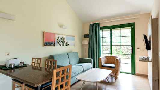 Rom med sittemøbler og spisebord, avbildet med grønn dør og interiør. (AI-generert tekst)