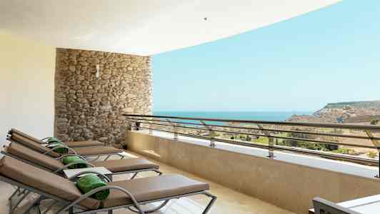 Terrasse med solsenger og havutsikt. (AI-generert tekst)