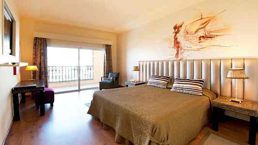 Rom med dobbeltseng, taklampe og utsikt mot balkong. (AI-generert tekst)