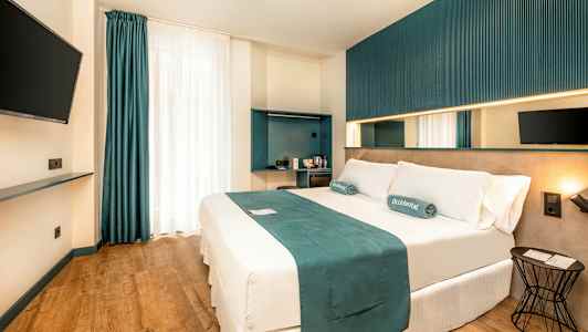 Et moderne hotellrom med en dobbeltseng, veggmontert TV og minimalistisk interiør. (AI-generert tekst)