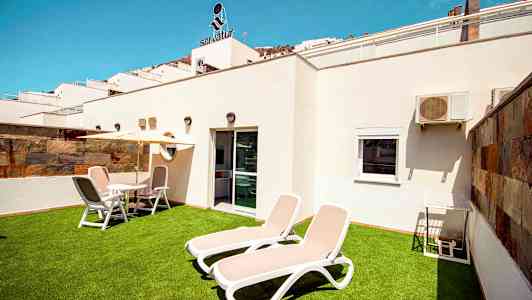 Privat terrasse med solsenger og utemøbler. (AI-generert tekst)