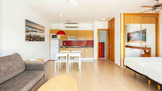 Et moderne hotellrom med åpen kjøkkenløsning og soveplass. (AI-generert tekst)