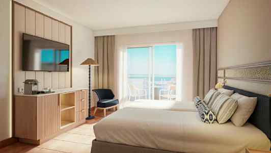 Et hotellrom med to senger, en flatskjerm-TV på veggen, møbler og en balkong med utsikt over havet. (AI-generert tekst)