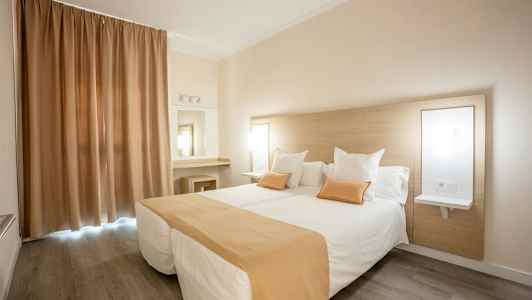 Hotellrom med to enkeltsenger, beige og hvitt fargevalg. (AI-generert tekst)