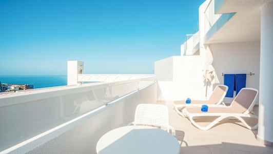 Terrasse med solsenger og fantastisk utsikt over havet. (AI-generert tekst)