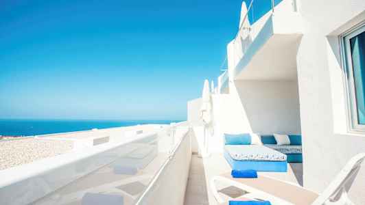 Terrasse med solsenger og havutsikt. (AI-generert tekst)