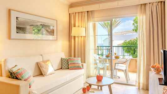 Interiør av lys stue med sofa, bord og åpning mot terrasse. (AI-generert tekst)