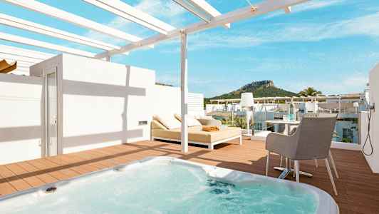 Terrasse med boblebad, solseng og utsikt mot frodige fjell. (AI-generert tekst)