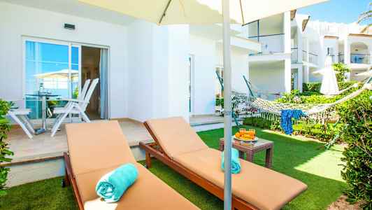 Bilde av en hage terrasse med solsenger, en hengekøye og en parasoll. (AI-generert tekst)