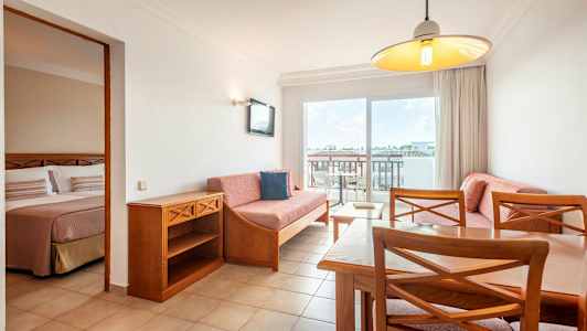 Leilighetsinteriør med stue og en del av soverommet synlig. (AI-generert tekst)