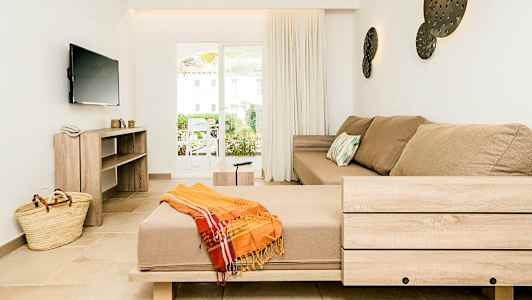 Innredningen i en lys stue med en beige sofa og en bred vindusdør. (AI-generert tekst)