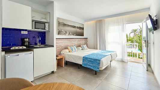 Bilde av et hotellrom med enkeltsenger, tekjøkken og en balkong med utsikt. (AI-generert tekst)