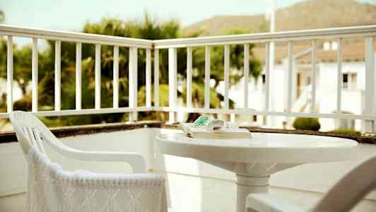 En treplatting med stoler og et bord, omgitt av rekkverk. (AI-generert tekst)