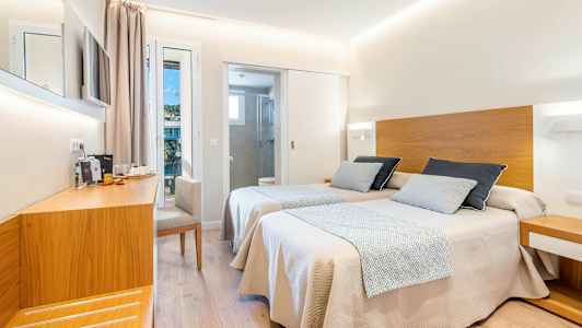 Et hotellrom med to enkeltsenger med tredetaljer, en arbeidsplass og adskilt bad. (AI-generert tekst)