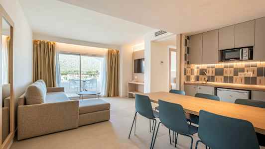 En moderne leilighet med stue, spiseområde og kjøkken. Store glassdører fører til en balkong. (AI-generert tekst)