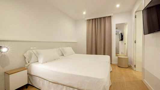 Et hotellrom med to senger dekket med hvitt sengetøy. (AI-generert tekst)