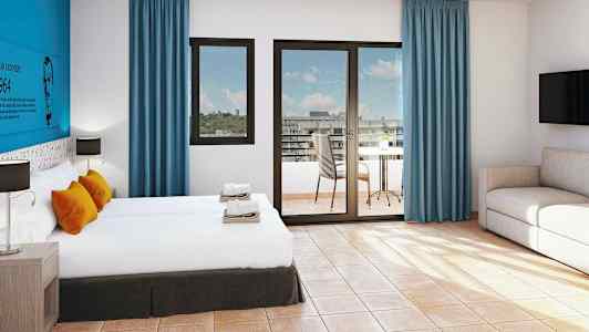 Et hotellrom med to senger, sittegruppe og et bord på balkongen. (AI-generert tekst)