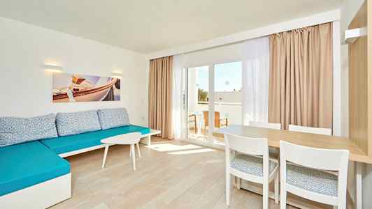 Lyst rom med blå sofa, et bord med stoler og glassdør til balkongen. (AI-generert tekst)