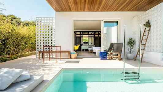 En moderne uteplass med basseng, sittemøbler og hagedekorasjoner. (AI-generert tekst)