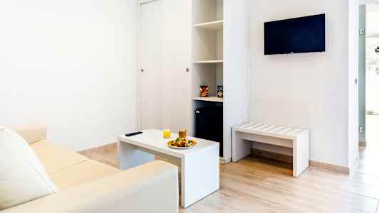 Interiør av en stue med sofa, salongbord og veggmontert TV. (AI-generert tekst)