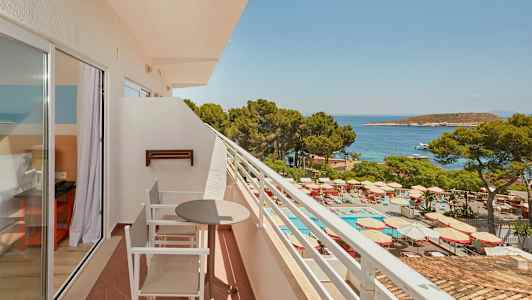 Balkong med utemøbler, utsikt over bassengområde og sjøen. (AI-generert tekst)