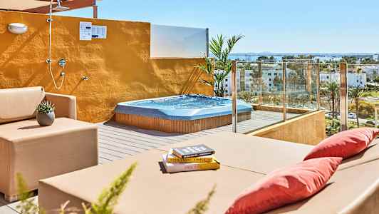 Terrasse med boblebad, sittemøbler og åpen dusj med utsikt over omgivelsene. (AI-generert tekst)