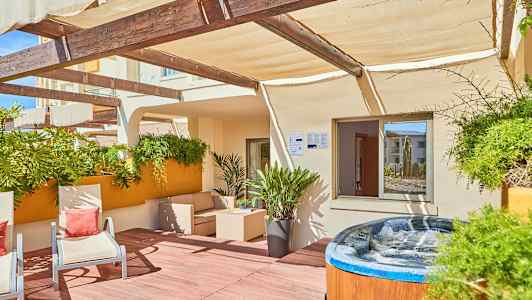 Terrasse med utemøbler, planter og et boblebad. (AI-generert tekst)