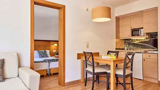 Et rom med kjøkken og spisebord, samt utsikt mot soverommet. (AI-generert tekst)