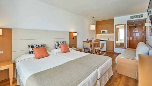 Et studio med to senger, sittemøbler og et kjøkken. (AI-generert tekst)