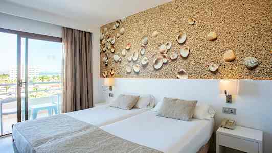 Hotellrom med to enkeltsenger, dekorativt bilde med skjell og balkong med utsikt. (AI-generert tekst)