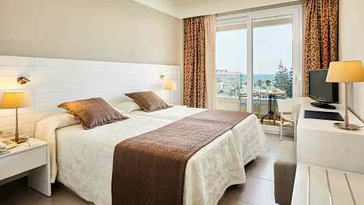 Hotellrom med to enkeltsenger og balkong. (AI-generert tekst)