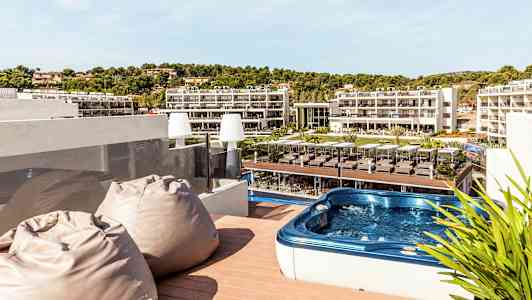 Terrasse med boblebad og utsikt over hotellområdet. (AI-generert tekst)