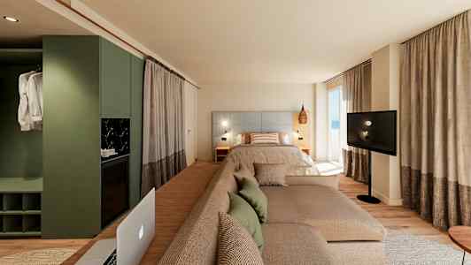 Moderne hotellrom med seng, sofa og TV foran store vinduer. (AI-generert tekst)