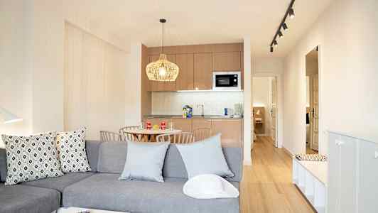 Moderne innredet stue med kjøkkenkrok og spisebord. (AI-generert tekst)