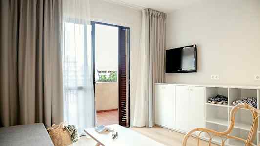 Moderne møblert hotellrom med åpen balkongdør. (AI-generert tekst)