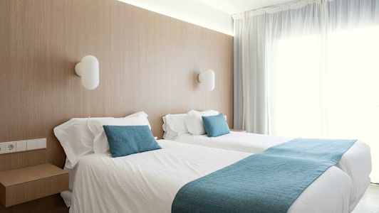 Rom med to enkeltsenger og myke blå detaljer. (AI-generert tekst)