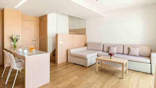 En moderne stue med tret detaljer, en sofa, et salongbord og et spiseområde med stoler. (AI-generert tekst)