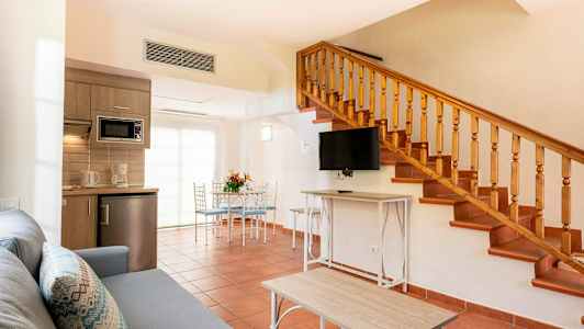 En stue med trapp, kjøkkenutstyr og spiseplass. (AI-generert tekst)