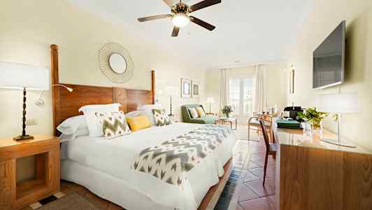 Et lyst hotellrom med dobbeltseng, tredetaljer og moderne innredning. (AI-generert tekst)