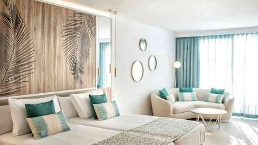 Et moderne hotellrom med to enkeltsenger, sittegruppe og dekorasjoner. (AI-generert tekst)