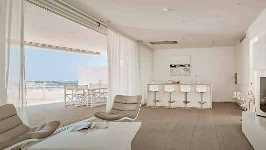 Bilde av en moderne stue med åpen planløsning, lyse møbler og utsikt mot en terrasse. (AI-generert tekst)