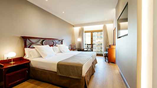 Hotellrom med dobbeltseng og balkong. (AI-generert tekst)