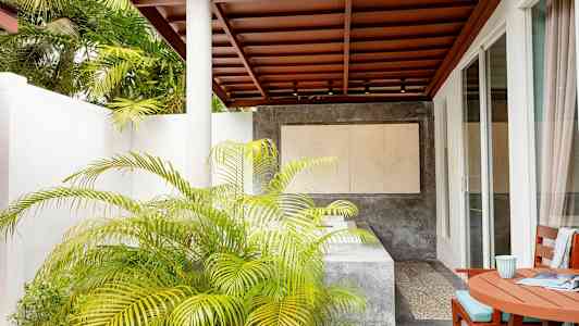 Terrasse med tak, bord og stoler, samt planter og moderne omgivelser. (AI-generert tekst)