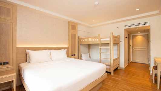 Hotellrom med en dobbeltseng og en køyeseng. (AI-generert tekst)