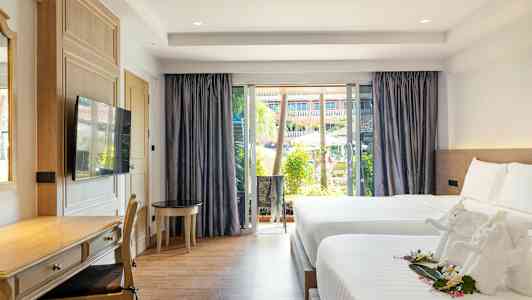 Et hotellrom med to senger, en skrivebordskrok og et stort vindu med utsikt over et basseng og hage. (AI-generert tekst)