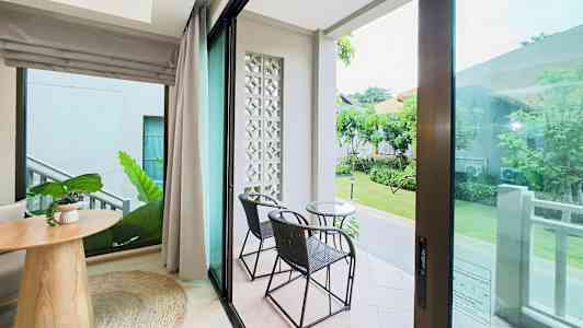 Utsikt fra et rom med glassdører til en terrasse med to stoler og et bord. (AI-generert tekst)