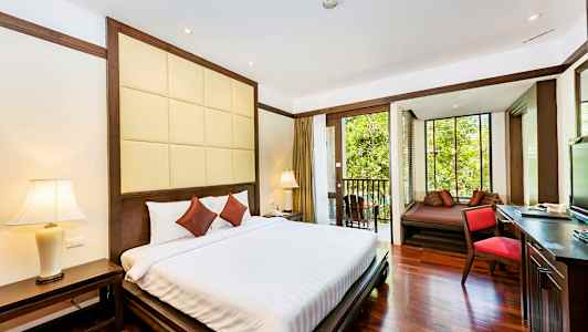 Hotellrom med dobbeltseng, nattbord og balkong med utsikt over vegetasjon. (AI-generert tekst)